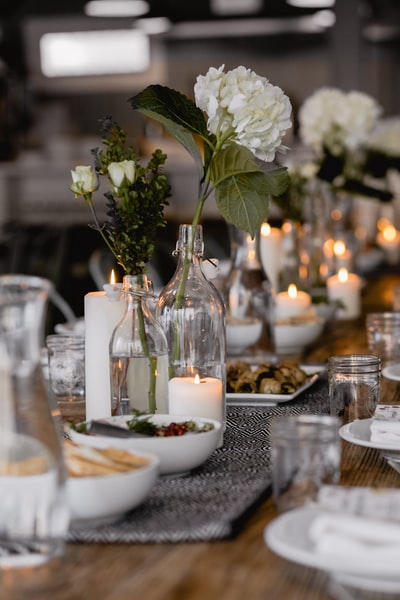 桌上蜡烛旁白花的选择性聚焦摄影